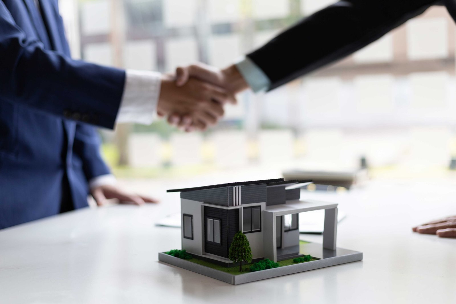 Asesor y cliente cerrando venta de casa